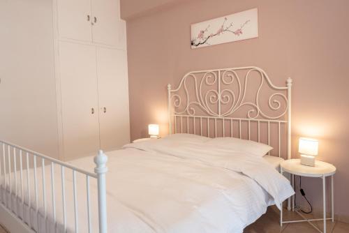 sypialnia z białym łóżkiem z dwoma lampami na stole w obiekcie Apartment_41 w Atenach