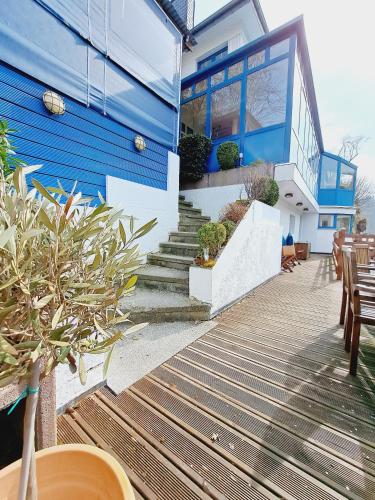 a blue and white building with stairs and potted plants at Gite Villa le Monde - La Roche-en-Ardenne in La Roche-en-Ardenne