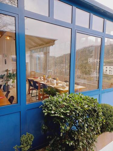 a glass extension to a house with a dining table at Gite Villa le Monde - La Roche-en-Ardenne in La Roche-en-Ardenne