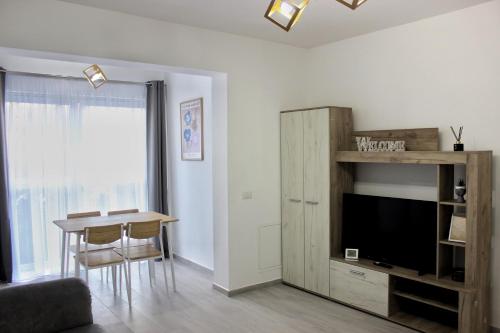 uma sala de estar com uma mesa de jantar e uma televisão em Deluxe Apartments on G Enescu Blvd near Stefan Cel Mare University Suceava em Suceava
