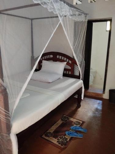 un letto a baldacchino in una stanza di Subira Guest House a Lamu
