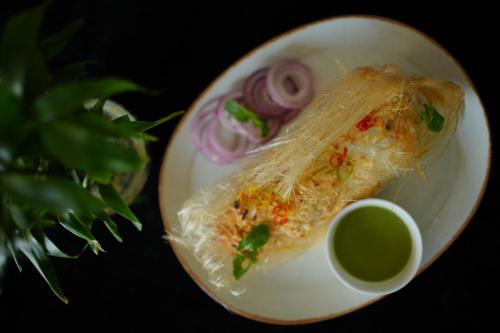 a plate of food with noodles and onions on it at Comfort Inn Karnal in Taraori