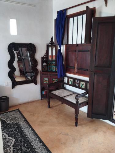 a living room with a bench and a mirror at Subira Guest House in Lamu