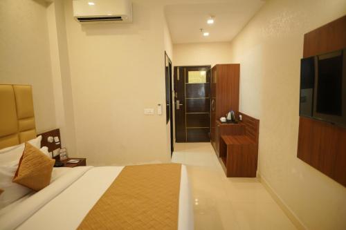 a hotel room with a bed and a television at Comfort Inn Karnal in Taraori