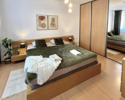 Un dormitorio con una cama grande con una manta verde. en Apartment Tina - Old Town, AC, Free Private Parking, en Bratislava