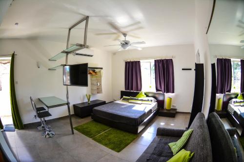 1 dormitorio con 1 cama, TV y sofá en Pinewood, en San Julián