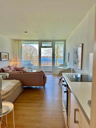 ein Wohnzimmer mit einem Sofa und einem Tisch in der Unterkunft Appartement mit traumhaftem Kieler Förde Blick in Kiel