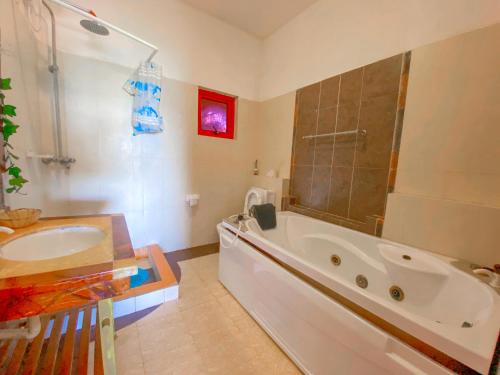 een badkamer met een groot bad en een wastafel bij Mfalme Beachfront Apartments in Mombasa