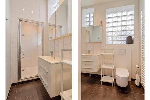 Un baño con dos lavabos y una ducha y un inodoro. en Villa Manalou Glv, en Wenduine