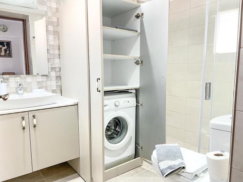 a white bathroom with a washer and dryer at La Casa di villagio in Koskinou