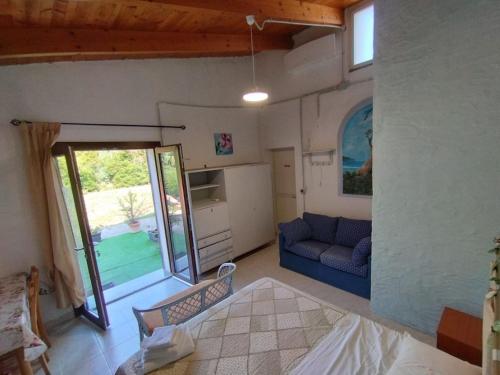 a living room with a blue couch and a window at Camera Serraona in Alghero