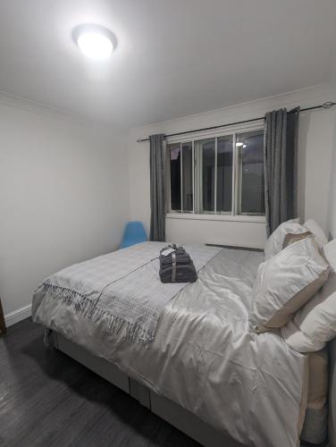 a bedroom with a bed and a window at Modern ground floor flat in Cranford