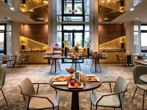ベルサイユにあるMgallery Le Louis Versailles Châteauのホテルのロビーには食べ物を置いたテーブルがあります。