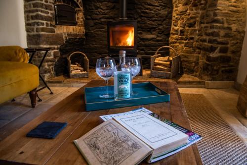 een tafel met twee wijnglazen en een boek bij Keepers Lodge in Knowstone