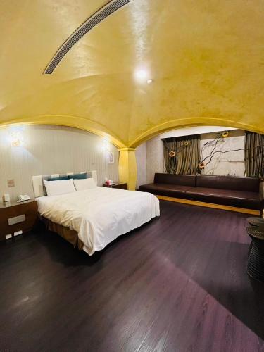 a bedroom with a large bed with a yellow ceiling at Walker Motel in Taipei