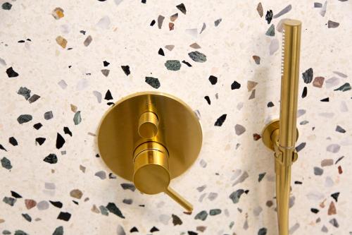 a gold wall light on a wall next to a wall at Aegean Stories pelagos suites in Avlákia