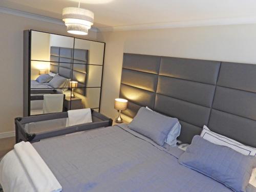 1 dormitorio con 1 cama grande y espejo grande en A Home from Home - Leamington Spa en Leamington Spa