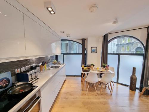a kitchen with a table and chairs in a room at Shard View Apartments in London