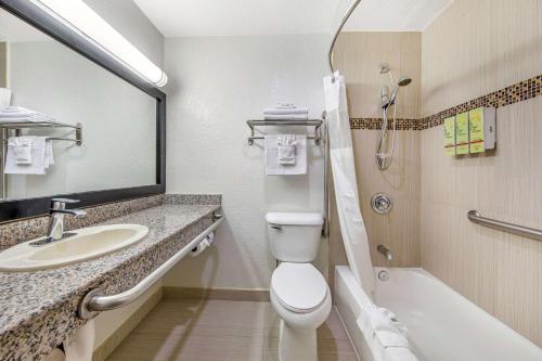 a bathroom with a toilet and a sink and a tub at Best Western Americana Inn in San Ysidro, San Diego