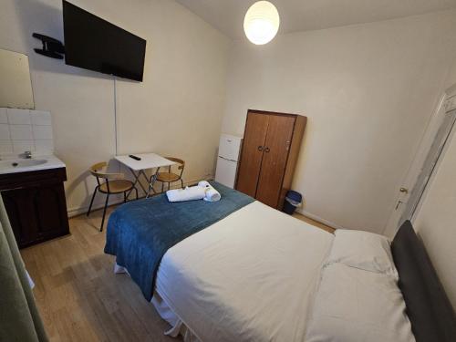 a bedroom with a bed and a sink and a desk at Bruce Rooms in London