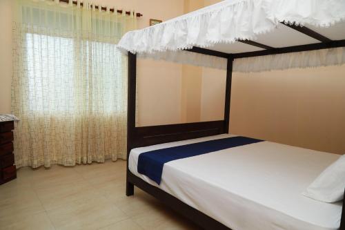 a bedroom with a bed with a canopy at Multi Villa Gold in Galle