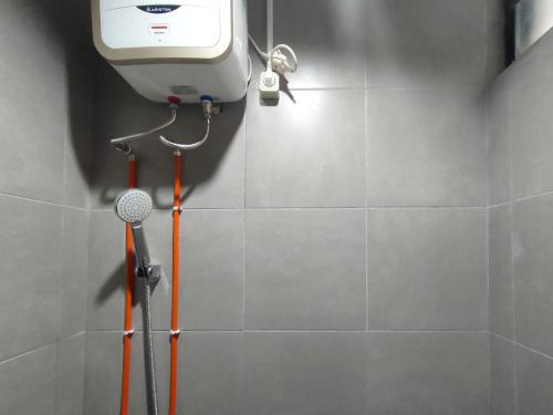 um chuveiro na casa de banho com secador de cabelo em RedDoorz Near Rumah Sakit Soewandhie em Surabaia