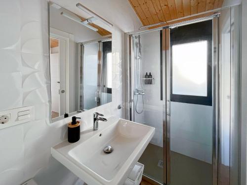 a white bathroom with a sink and a shower at Picú Home in Málaga