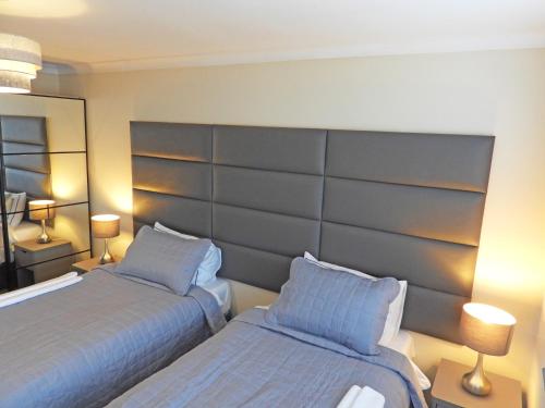 a bedroom with two beds and a large headboard at A Home from Home - Leamington Spa in Leamington Spa