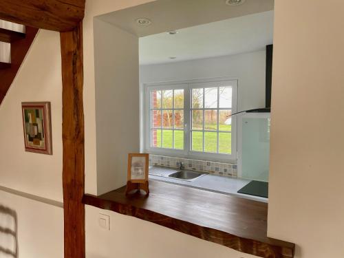 uma cozinha com um lavatório e uma janela em Cottage 4 chambres avec cheminée em Épégard