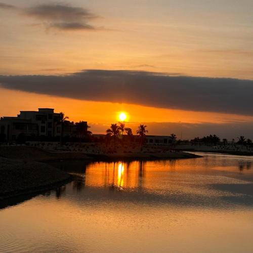 a sunset over a body of water with the sun setting at Hawana Salalah luxury 1BR TH with private pool in Ma‘mūrah
