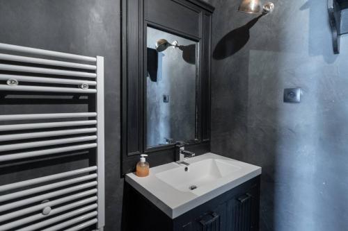 a bathroom with a white sink and a mirror at BEACH HOUSE in Les Grenettes