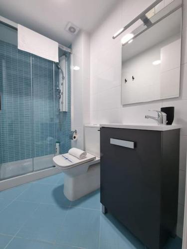 a bathroom with a toilet and a sink and a shower at VibesMalpica - Canido 12 in Malpica