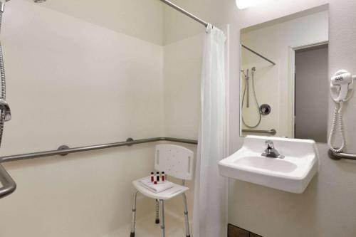 a white bathroom with a sink and a mirror at Travelodge by Wyndham Hermiston in Hermiston