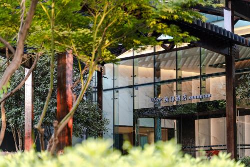 a glass building with a sign on the side of it at UrCove by Hyatt Shanghai Pudong East in Shanghai