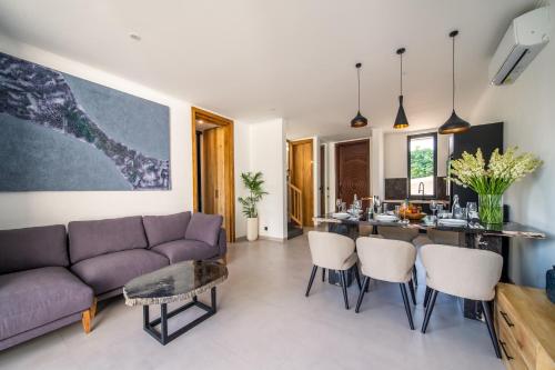 a living room with a purple couch and a table at Sunny Village Berawa in Canggu