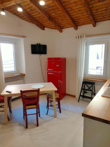 a kitchen with a table and chairs and a red cabinet at Casa Storta - Cycle Garage CON BICICLETTE in Pisogne