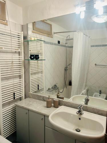 a white bathroom with a sink and a mirror at Civico 7 in Clusane sul Lago