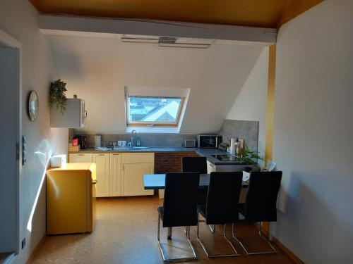 a kitchen with a table and some black chairs at Ferienwohnung im roten Haus in Bad Ems