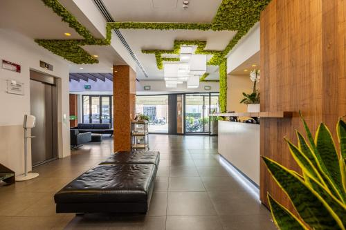 an office lobby with a black leather bench in the middle at Best Western Plus Hotel De Capuleti in Verona