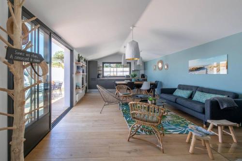 un salon avec un canapé bleu et des chaises dans l'établissement Maison d'architecte avec piscine à deux pas de la plage des Grenettes, à Les Grenettes