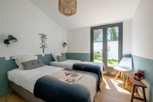 Ένα ή περισσότερα κρεβάτια σε δωμάτιο στο Maison d'architecte avec piscine à deux pas de la plage des Grenettes