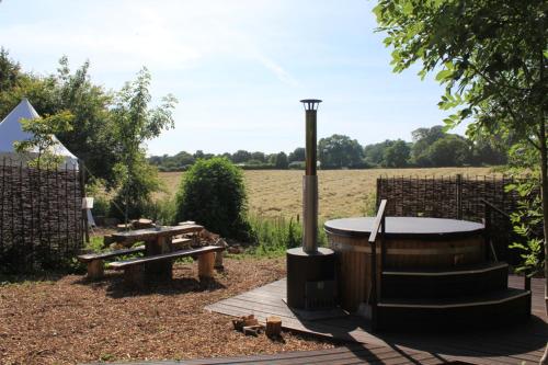 a picnic area with a hot tub and a picnic table at Elessar Yurt Village in Hawkley