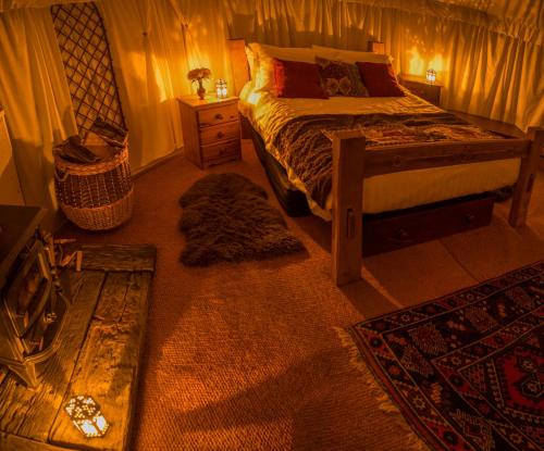 a bedroom with a bed in a room with rugs at Elessar Yurt Village in Hawkley