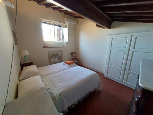 ein Schlafzimmer mit einem großen weißen Bett und einem Fenster in der Unterkunft Apt in Via Ginori in a historical palazzo with elevator in Florenz