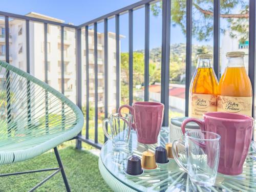 - une table en verre avec deux bouteilles de boissons sur le balcon dans l'établissement Le Palm by Winsome Destination, à Cannes