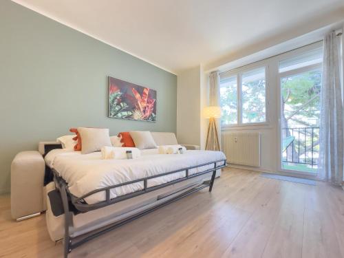 une chambre avec un lit et une grande fenêtre dans l'établissement Le Palm by Winsome Destination, à Cannes