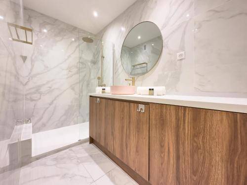 une salle de bain avec un lavabo et un miroir dans l'établissement Le Palm by Winsome Destination, à Cannes