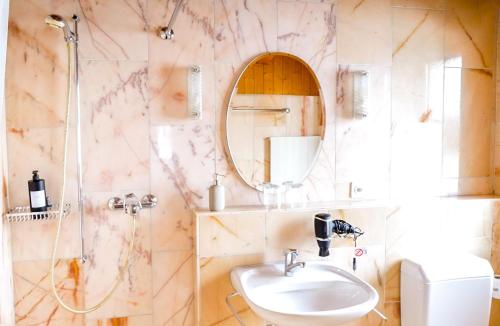 ein Bad mit einem Waschbecken und einem Spiegel in der Unterkunft Hotel Postigliun Sedrun in Sedrun