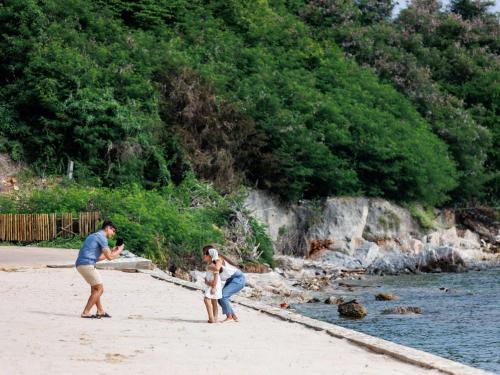 a man and a woman standing on a beach at Novotel Koh Si Chang in Ban Phanu Rangsi