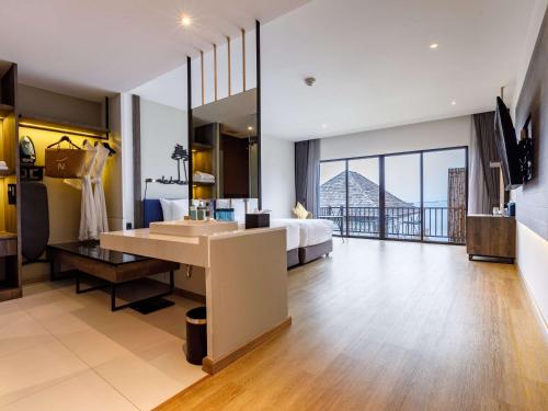 a hotel room with a bed and a large bathroom at Novotel Koh Si Chang in Ban Phanu Rangsi